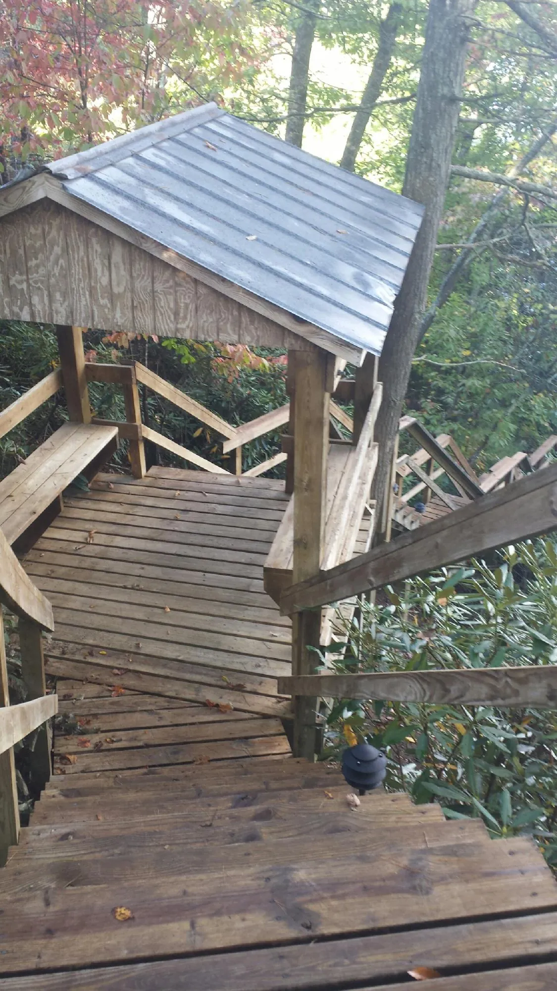Metal roofed shelter over wooden steps on a wooded walkway — Skylight Repair & Installation work by our crew in Sheridan